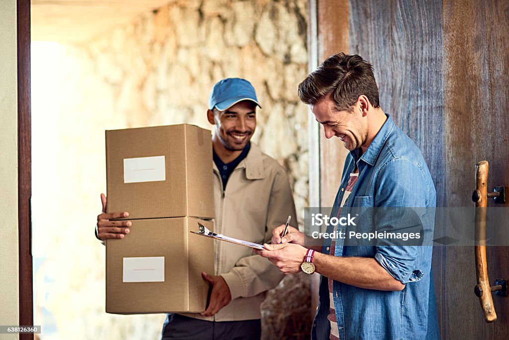 Right on time! Cropped shot of a courier making a delivery to a customer at his home Delivery Person Stock Photo