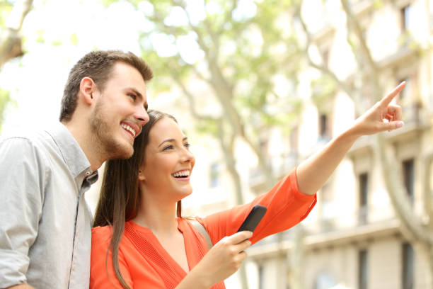 happy couple searching home in the street - for rent sign house sign happiness imagens e fotografias de stock