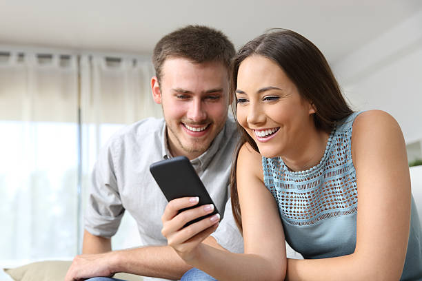 istock Couple consulting a mobile phone at home 638128704
