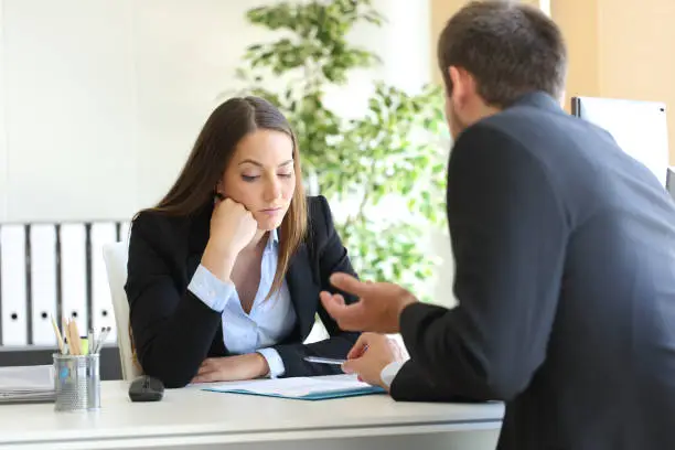 Bad salesman trying to convince to a bored client in her office or businessman in a job interview