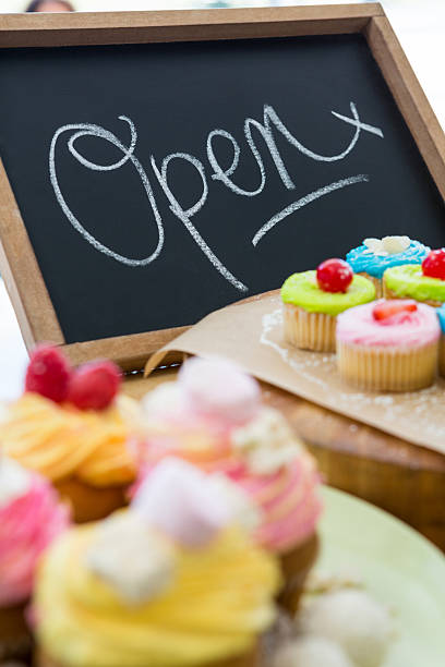 istock Close-up of various cupcakes on table with open signboard 638132506