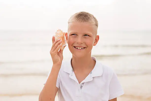 Photo of Little boy holding a seashell