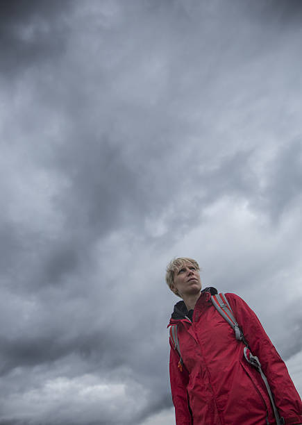 istock Young woman standing under a stormy sky 638135920
