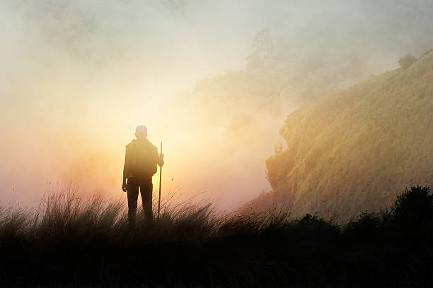 istock Woman backpacker hiking on mountain peak cliff in the mist 638136602