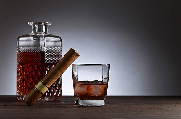 istock Glass of whiskey with cogar on a wooden table 638139704