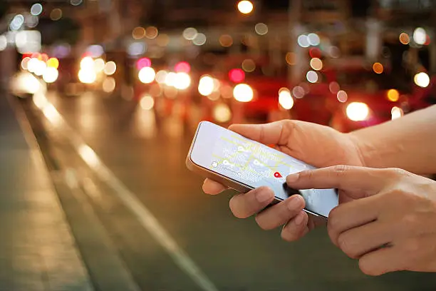 Photo of man using navigation app on the smartphone on street