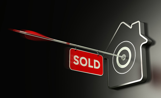 3D illustration of at home shaped target over black background and one arrow in the center with a sign where it is written the word sold. Concept of real estate