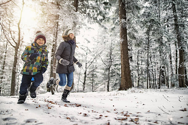 happy kids running in beautiful winter forest or park - family winter walking fun imagens e fotografias de stock