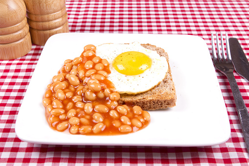 A light lunch time snack fried egg on toast with beans