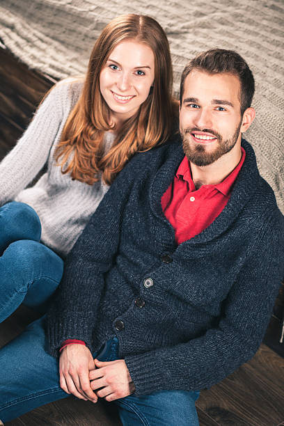 若いカップルの自宅で - brick red wool heat ストックフォトと画像