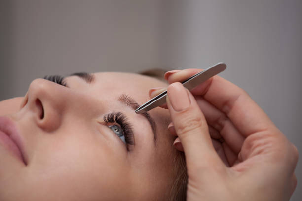 istock Makeup artist plucks his eyebrows at the girl. 638156792