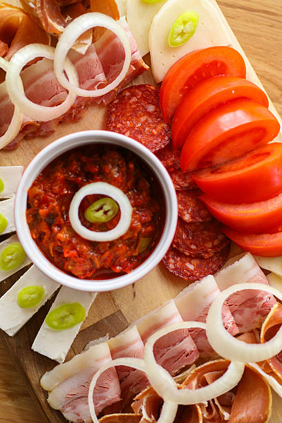 istock Various appetizers: ham, bacon, sausage, prosciutto, cheese, tomato 638162882