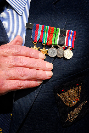 Auckland, New Zealand - April 25, 2007: A returned serviceman (veteran) places his hand on his medals during an ANZAC Day service in Auckland.  The service is held every year on April 25.