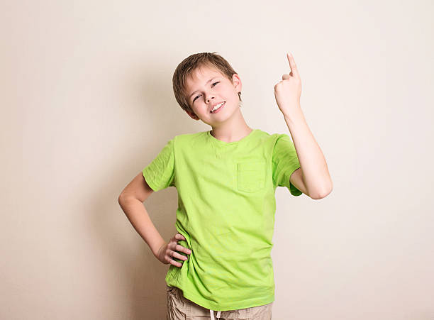 istock Cheerful teen boy pointing up over white background 638167530