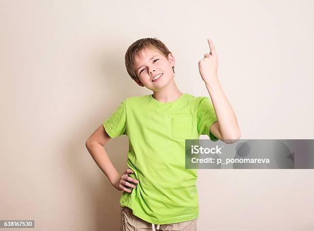 Cheerful Teen Boy Pointing Up Over White Background Stock Photo - Download Image Now
