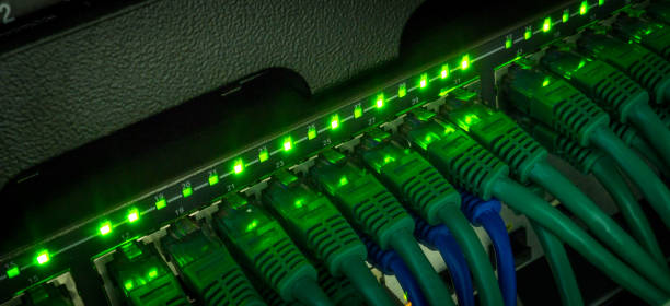 Server rack with green internet patch cord cables Server rack with green internet patch cord cables connected to black patch panel in server room horizontal. Glowing in dark computer network router communication internet stock pictures, royalty-free photos & images