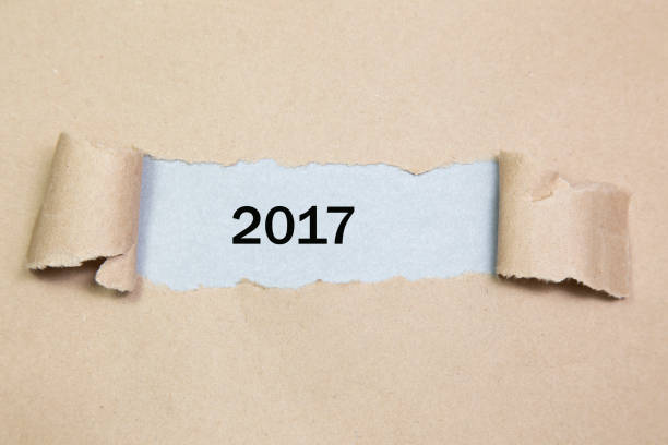 istock Year 2017 appearing behind ripped brown paper. 638170104