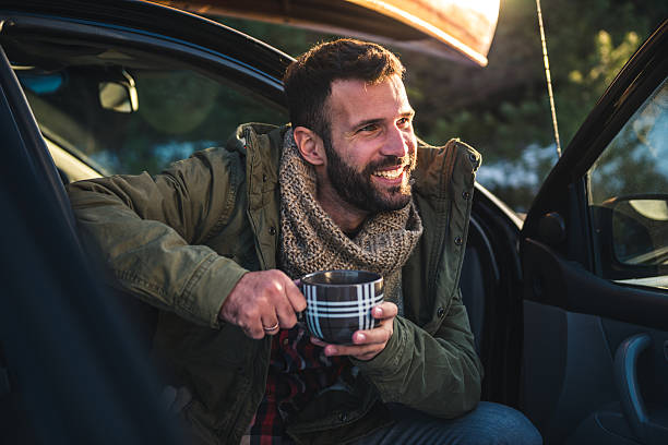 Making a break Handsome man drinking coffee while sitting in a car. hot handsome man stock pictures, royalty-free photos & images