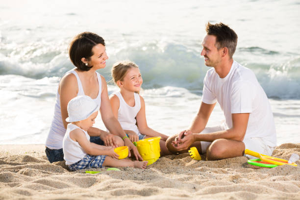 istock Laughing family with children playing at beach 638179324