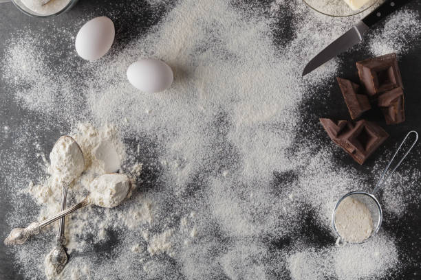 istock Baking cake ingredients. Bowl, flour, eggs, eggbeater on black c 638180964