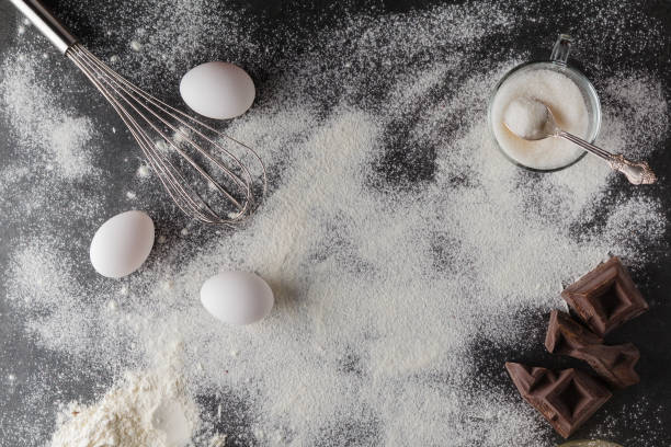 istock Baking cake ingredients. Bowl, flour, eggs, eggbeater on black c 638181004