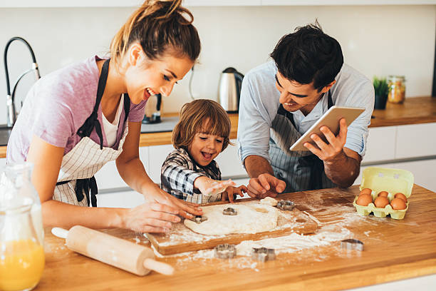 familie in der küche machen cookies - two parent family indoors home interior domestic kitchen stock-fotos und bilder