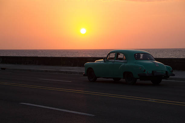 istock Green classic car driving on the Malecon during sunset 638184370