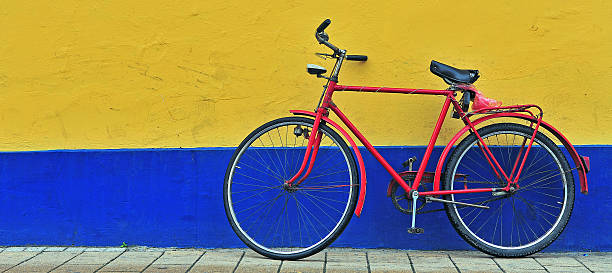 istock Red bicycle in front of the yellow and blue wall 638185036