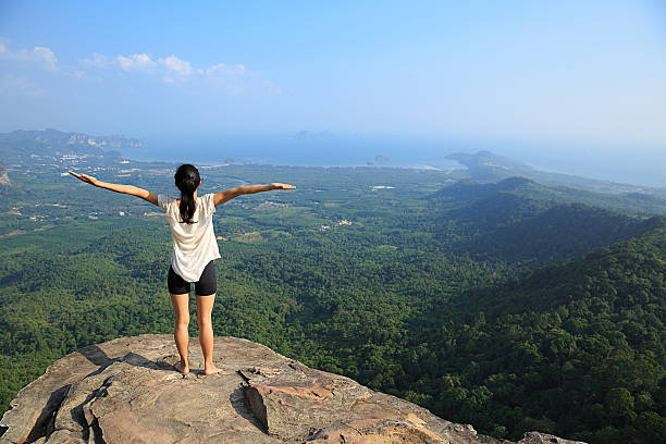 istock young freedom woman open arms on mountain peak 638185754