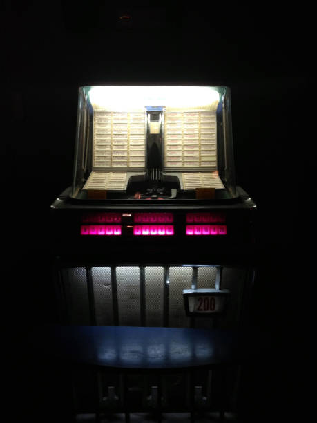 Vintage American jukebox lite up, in a dark room or bar/pub/club.
