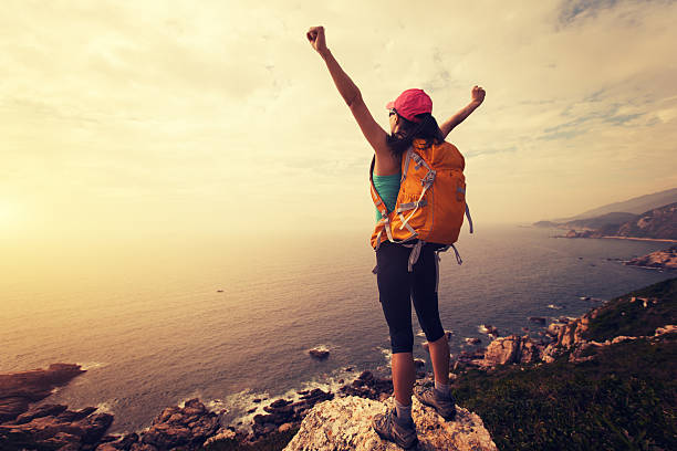 istock successful hiker hiking on seaside mountain peak rock 638190122
