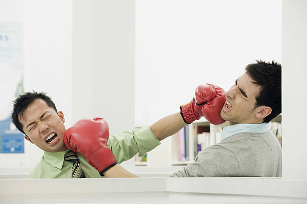 paire de collègues de bureau se battant avec des gants de boxe au bureau - emotional stress ideas bullying office photos et images de collection