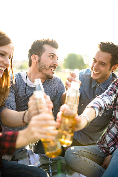 のグループ大学生笑う栄華トゥギャザネス - after work beautiful people beer beer bottle ストックフォトと画像