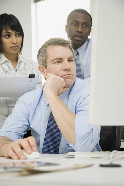 istock Group of business people looking at computer screen in office 638191198
