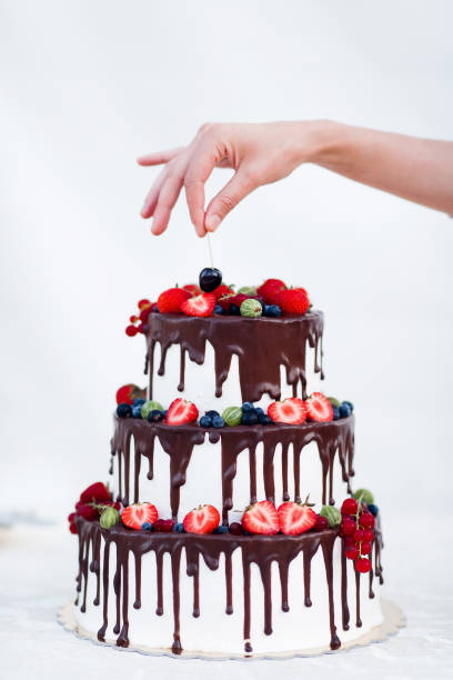 istock Tree story cake with hand putting cherry on the top 638193022