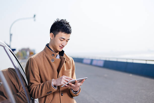 istock young asian man with tablet on road 638198126