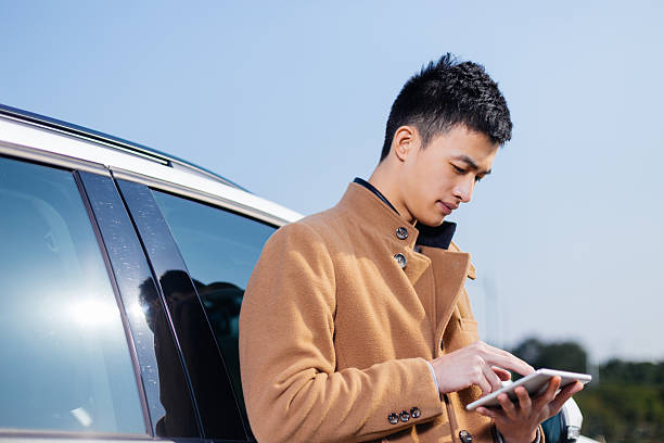 istock young asian man with tablet on road 638198212