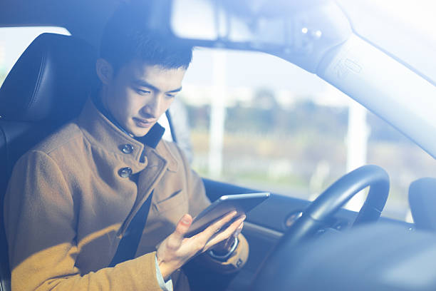 istock young asian man  hold tablet in car 638198346