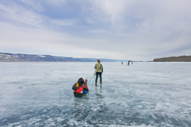 istock Girl with sledge and trekking pole is on ice 638203404