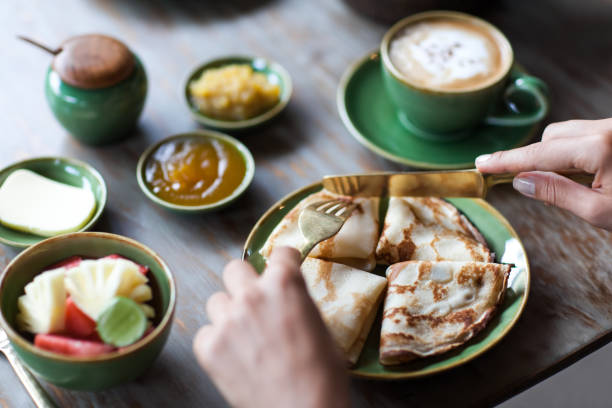 istock Young woman having breakfast and cut pancakes 638209626