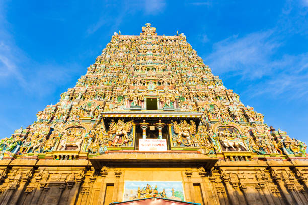 Madurai Meenakshi Amman Temple West Tower Centered Centered west tower gateway of Meenakshi Amman Temple covered in colorful statues of gods on a blue sky day at Madurai in south Indian state of Tamil Nadu, India menakshi stock pictures, royalty-free photos & images