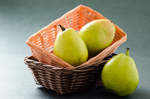 Fresh pears fruit in a basket on green background,healthy food