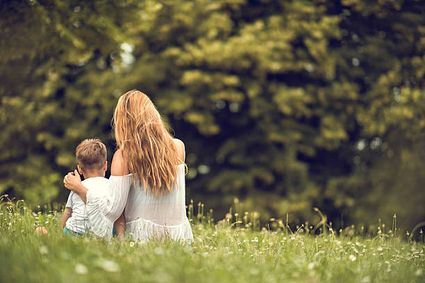 istock Back view of a mother and son relaxing in grass. 638216694