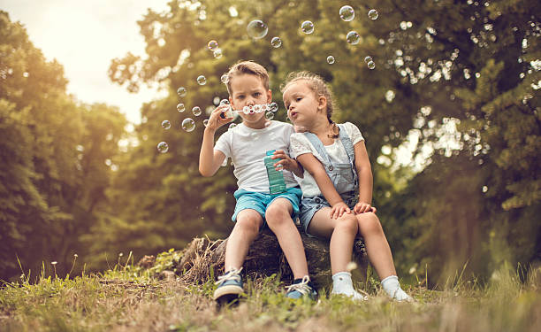 istock Two cute kids blowing bubbles in the park. 638217068