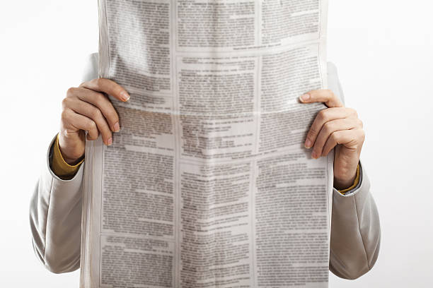 istock Woman reading newspaper on white background 638218416