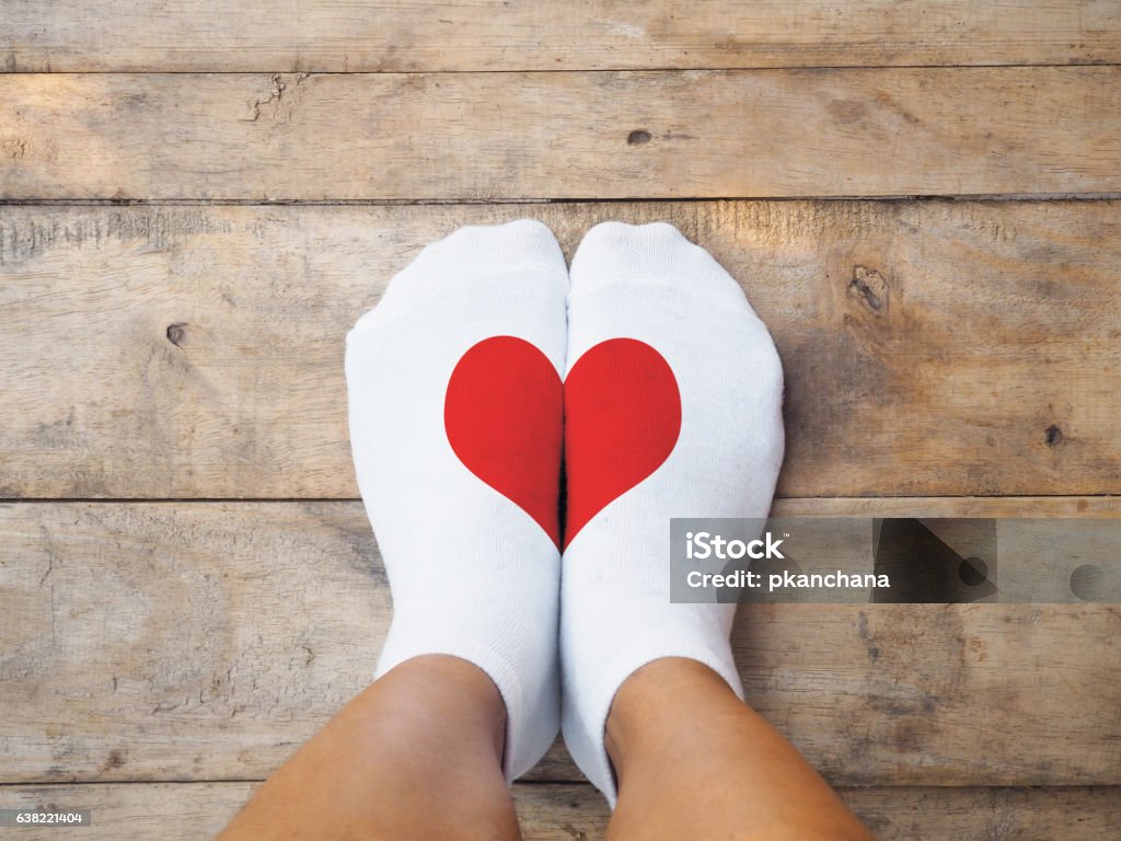 pieds portant des chaussettes blanches avec une forme de cœur rouge - Photo de Chaussette libre de droits