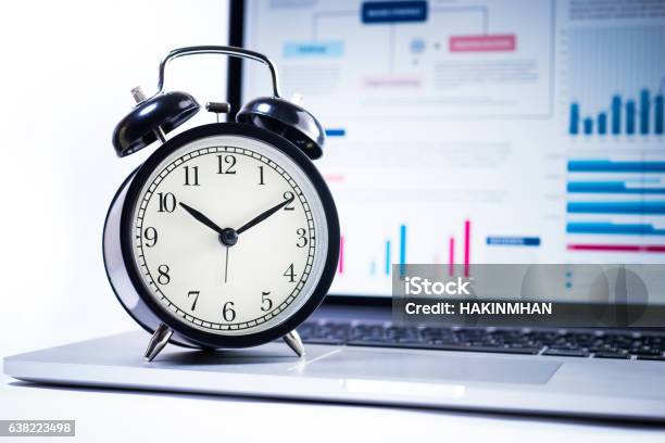 Alarm Clock With Stock Graph Chart In Laptop Screen Background Stock Photo - Download Image Now