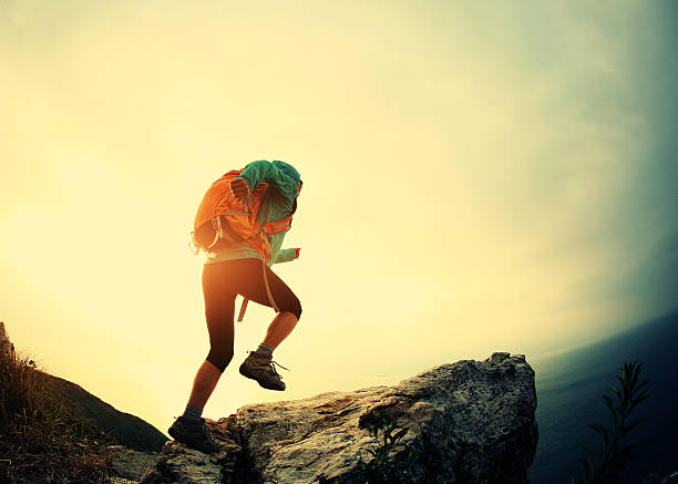 istock successful hiker running on seaside mountain peak rock 638223572