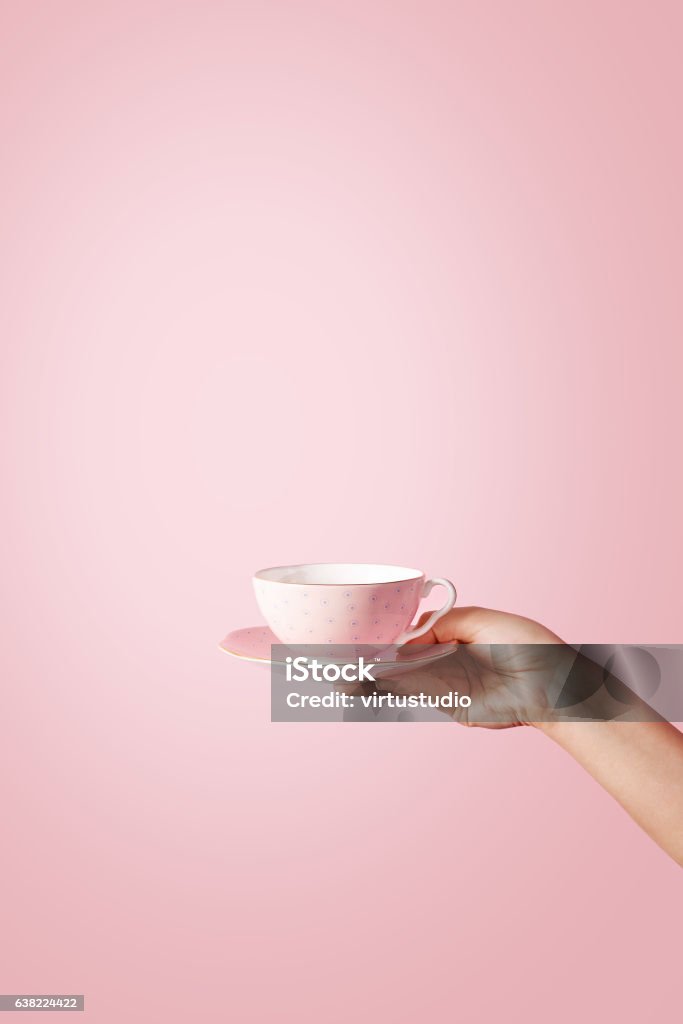 Woman hand holding a teacup on pastel background Tea Cup Stock Photo