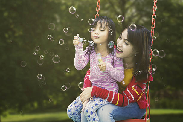 istock Cute girl and mother blowing soap bubbles 638224640
